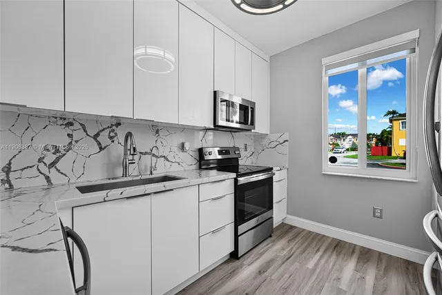 a kitchen with stainless steel appliances granite countertop a sink and a stove