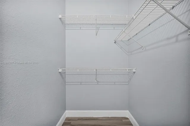 a view of a room with wooden floor and a window
