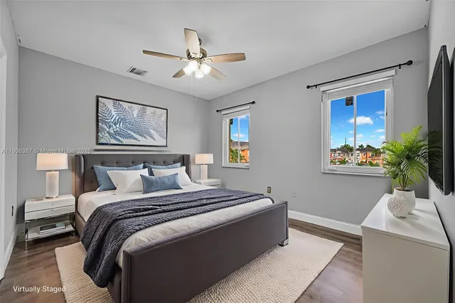 a view of empty room with wooden floor and fan