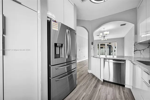 a kitchen with stainless steel appliances granite countertop a refrigerator and a stove top oven