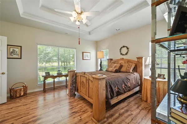 a spacious bedroom with a bed a table chair and a large window