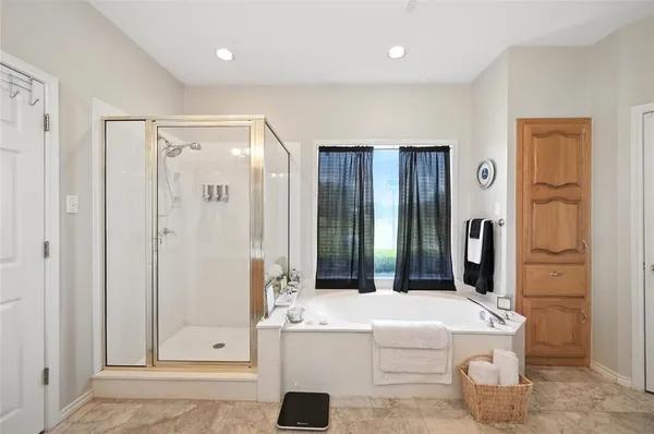 a bathroom with a tub sink and mirror