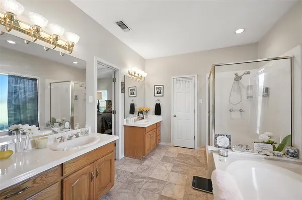 a spacious bathroom with a bathtub shower sink double and mirror