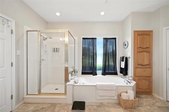 a bathroom with a tub sink and mirror