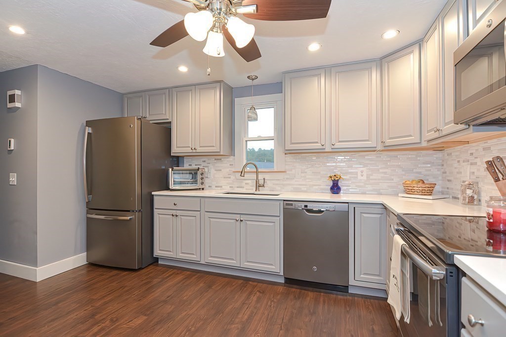 12 Oxbow Road Charlton, MA 01507 - Photo 10 of 40 a kitchen with stainless steel appliances granite countertop a refrigerator a sink dishwasher a stove and white cabinets with wooden floor
