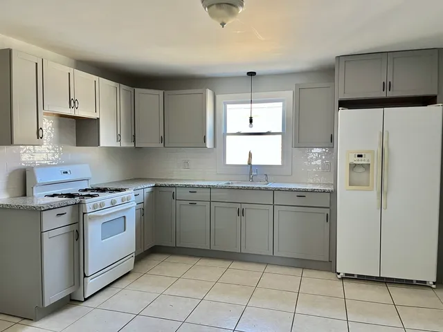 a kitchen with granite countertop cabinets and window