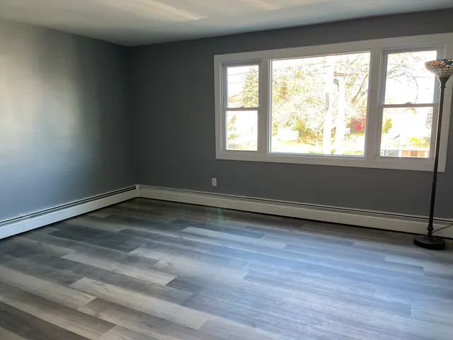 a view of a room with wooden floor and a window