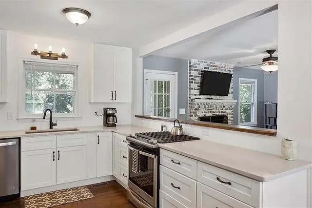 a kitchen with granite countertop a sink stove and cabinets