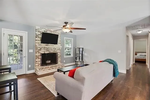 a living room with furniture a flat screen tv and a fireplace