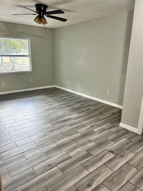 37 Cedar Tree Terrace Ocala, FL 34472 - Photo 6 of 21 an empty room with wooden floor fan and windows