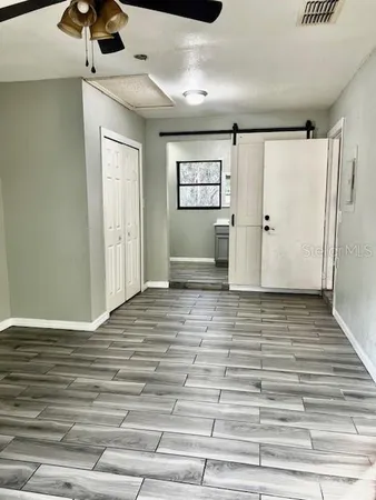 a view of a livingroom with a ceiling fan and wooden floor