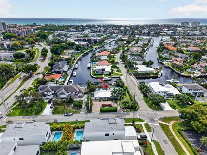 an aerial view of a city with lots of residential buildings ocean and mountain view in back