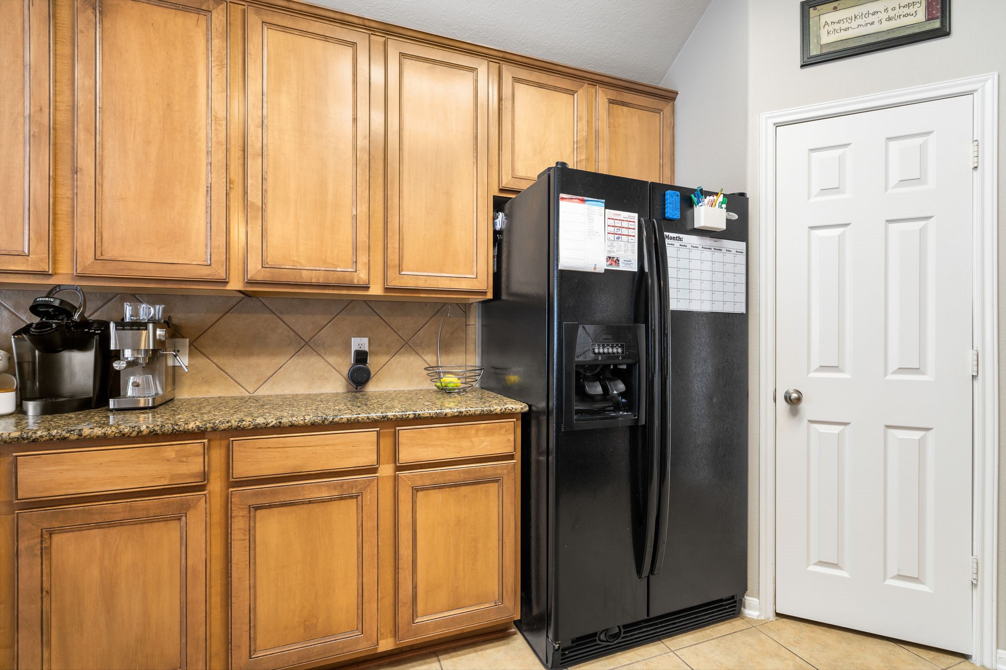 20903 Manon Lane Spring, TX 77388 - Photo 14 of 31 a kitchen with granite countertop a refrigerator and cabinets