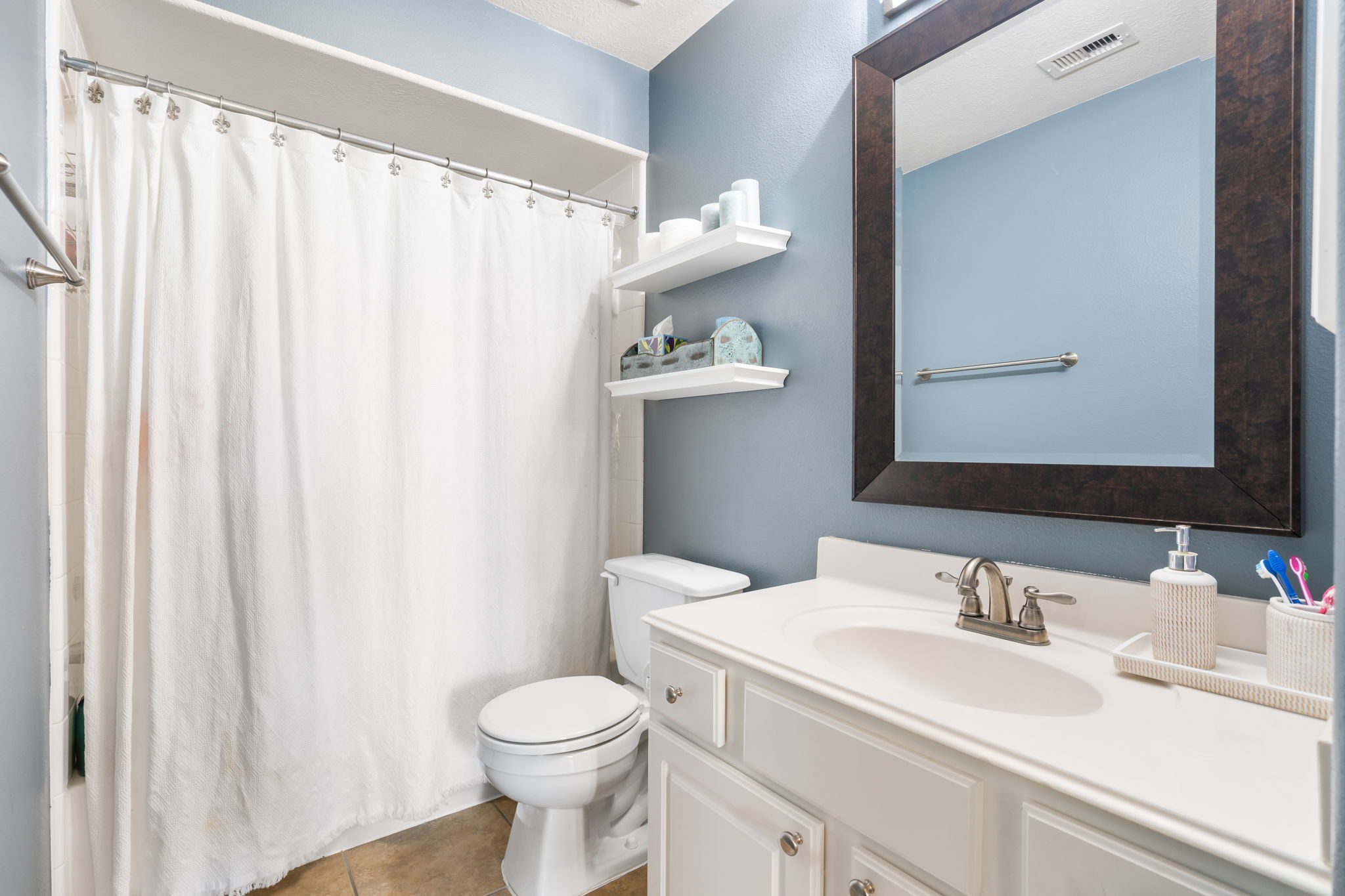 20903 Manon Lane Spring, TX 77388 - Photo 25 of 31 a bathroom with a sink a toilet and shower curtain