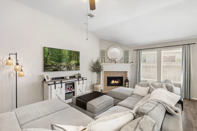 a living room with furniture a flat screen tv and a fireplace