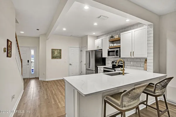a kitchen with a table chairs refrigerator and microwave