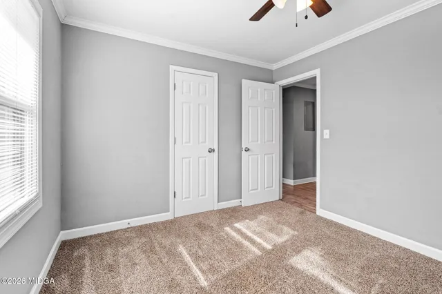 a view of a room with a ceiling fan and window