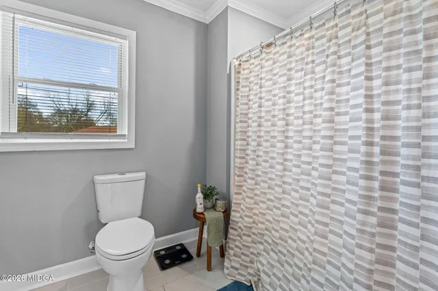 a bathroom with a toilet and a shower curtain