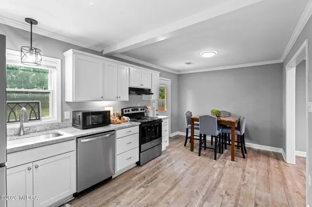 a kitchen with white cabinets stove and kitchen island