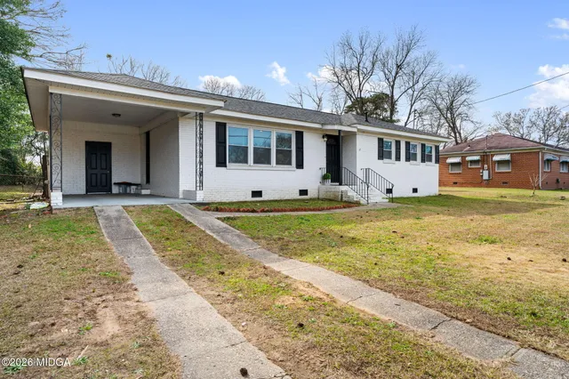 a view of a house with swimming pool and a yard