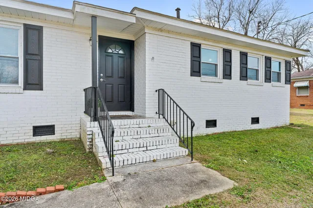 a view of a house with a yard and porch