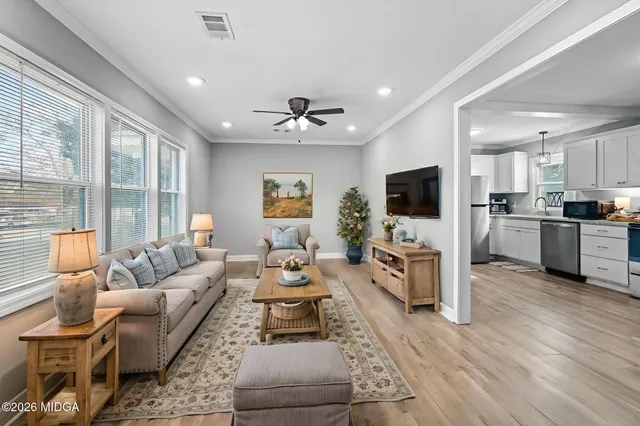 a living room with furniture flat screen tv and large window