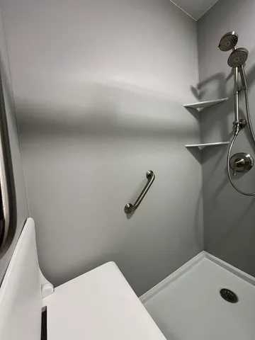 a bathroom with a toilet and a shower