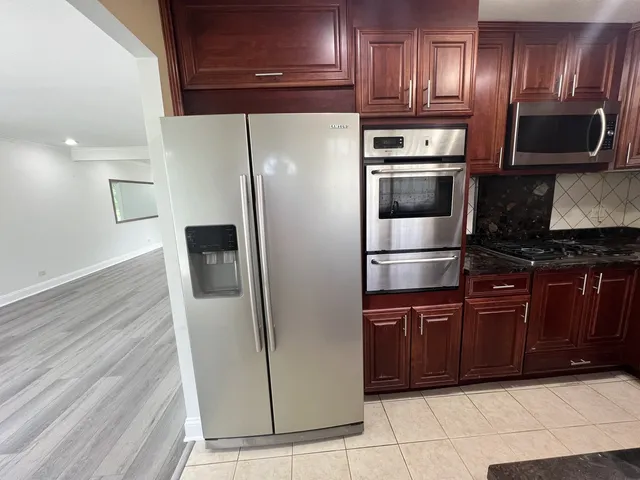 a kitchen with stainless steel appliances granite countertop a refrigerator and a sink