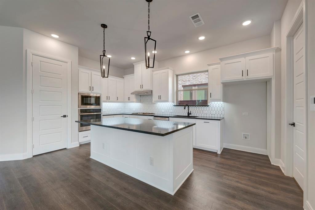 1857 Lightner Road Van Alstyne, TX 75495 - Photo 20 of 29 a kitchen with stainless steel appliances granite countertop a sink a stove and a wooden floor