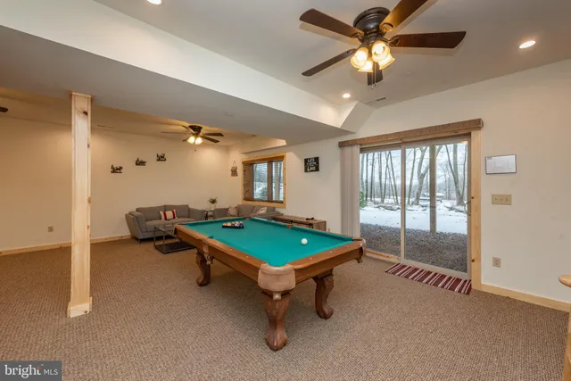a room with pool table and fan