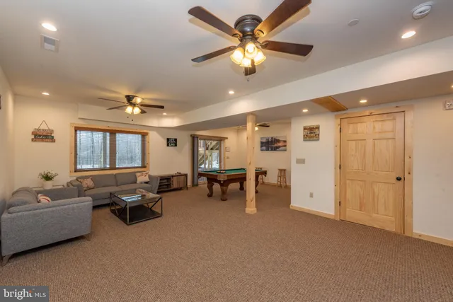 a living room with furniture and a ceiling fan