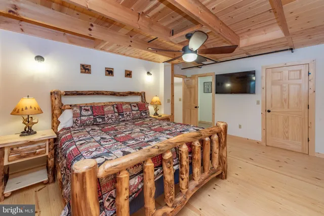 a bedroom with a bed a flat screen tv and a chandelier