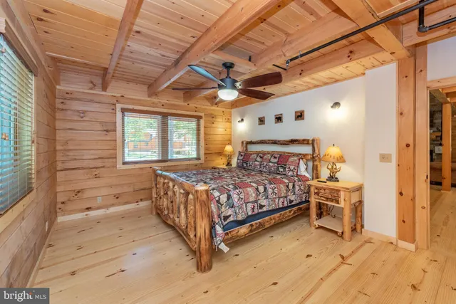 a bedroom with a bed next to a window with a chandelier