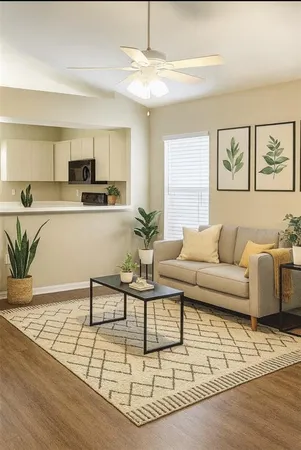 a living room with furniture and a dining table with wooden floor