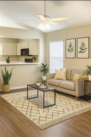 a living room with furniture and a dining table with wooden floor