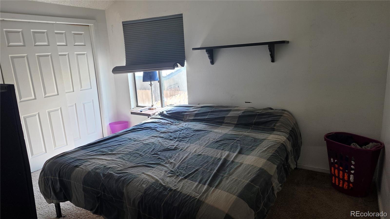 3771 South Danube Circle Aurora, CO 80013 - Photo 13 of 25 a bed sitting in a bedroom next to a window