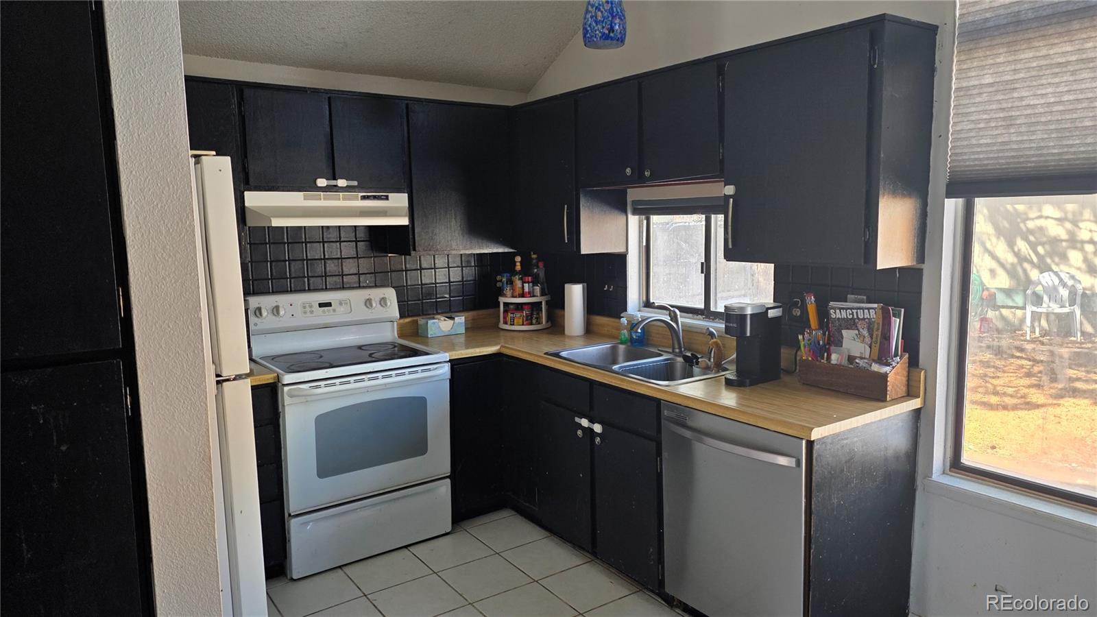 3771 South Danube Circle Aurora, CO 80013 - Photo 9 of 25 a kitchen with a sink a stove a microwave and refrigerator