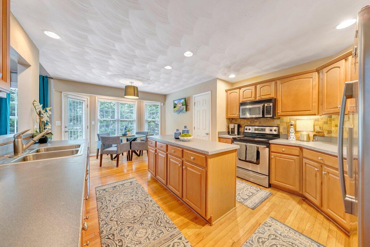 3770 Laurel Ridge Road Northwest Roanoke, VA 24019 - Photo 16 of 55 a large kitchen with kitchen island granite countertop a large counter top stainless steel appliances a stove a sink a dining table and chairs