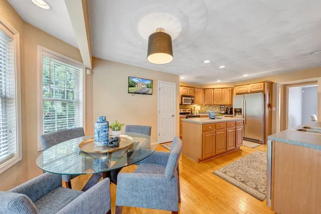 a kitchen with a table chairs sink and refrigerator