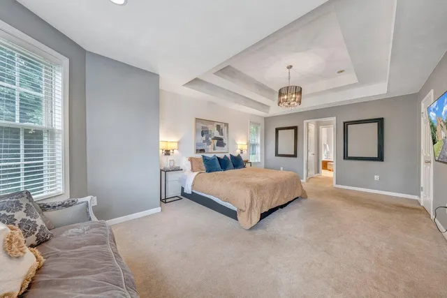 a bedroom with bed and a chandelier