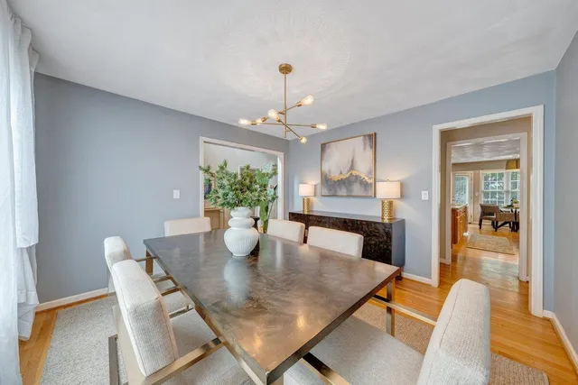 a dining room with furniture a chandelier and wooden floor