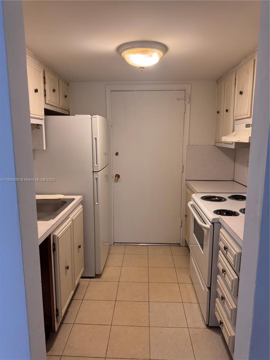 15888 Southwest 95th Avenue, Unit 201 Miami, FL 33157 - Photo 15 of 27 a kitchen with a stove a refrigerator and a sink