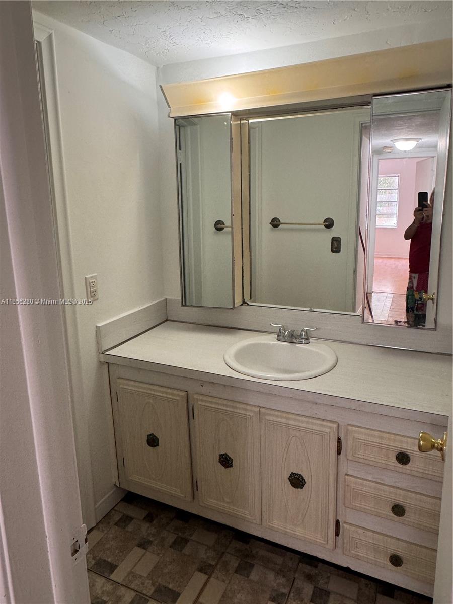 15888 Southwest 95th Avenue, Unit 201 Miami, FL 33157 - Photo 17 of 27 a bathroom with a granite countertop sink and a mirror
