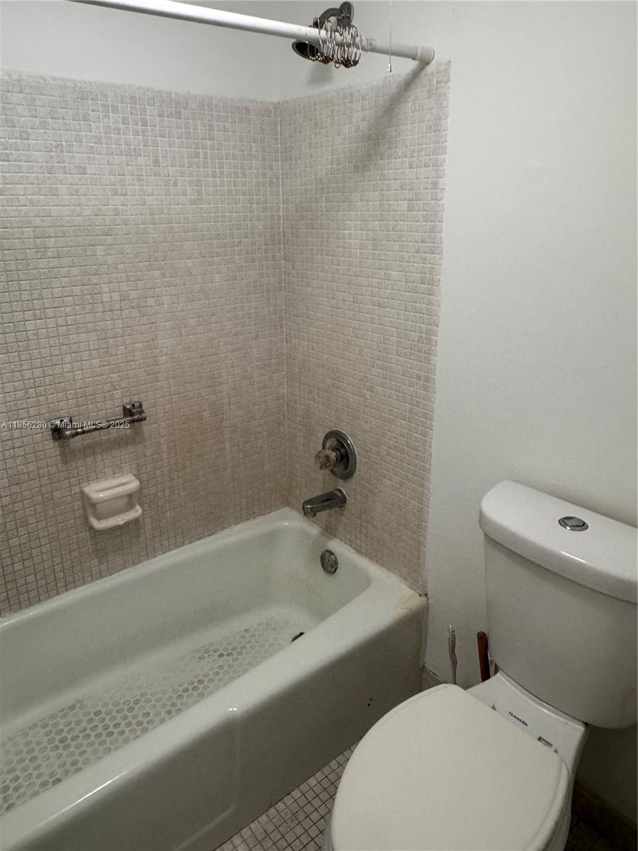 15888 Southwest 95th Avenue, Unit 201 Miami, FL 33157 - Photo 19 of 27 a white toilet sitting next to a bath tub