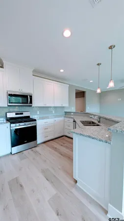 a kitchen with stainless steel appliances granite countertop a stove a sink and a refrigerator