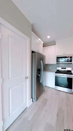 a kitchen with stainless steel appliances a refrigerator and a stove top oven