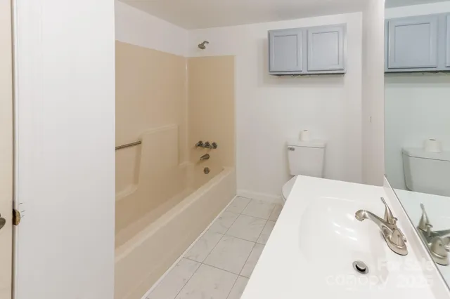 a bathroom with a tub sink and mirror