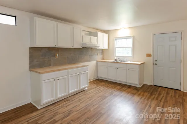 a view of a kitchen with sink cabinets and wooden floor