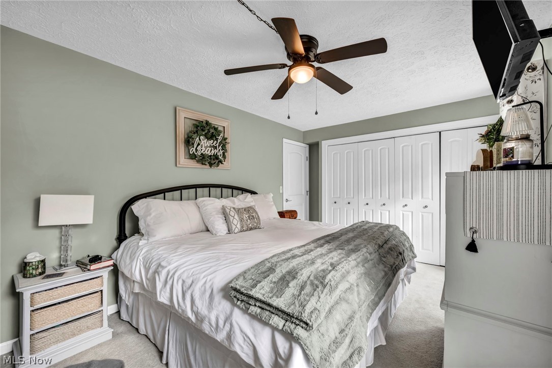 9753 Prospect Road Strongsville, OH 44149 - Photo 16 of 39 Bedroom featuring a textured ceiling, a closet, carpet flooring, and ceiling fan