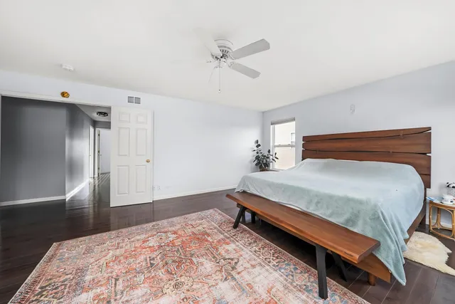 a bedroom with a bed and a ceiling fan